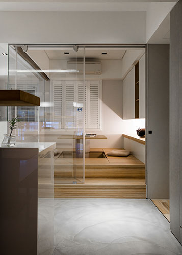 透明的玻璃門窗設計讓多功能房與其它空間沒有區隔，平時可以當和室使用，必要時也可以拉下風琴簾，增加隱蔽性。加上架高處理設計，除了置入升降桌提供多功能運用，底下亦可有大容量的收納空間。