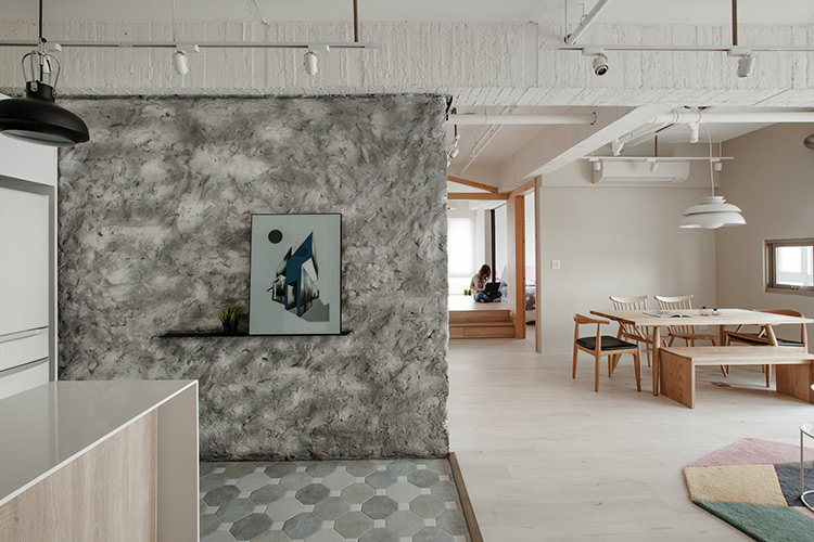 玄關進門後，映入眼簾是充滿手感肌理的泥作牆，巧妙的坎入黑色五金板，可以擺上喜歡的畫作或是小盆栽。