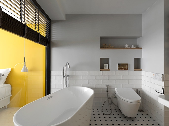 受限於原有管線配置,對內的浴室空間無法接受到外界採光。透過透明玻璃的使用改善採光不良的問題,穿透性的視覺感受也避免掉使用實牆對原有就不大的空間可能造成的壓迫感,同時以加裝拉簾的方式回應使用習慣並解除隱私疑慮。