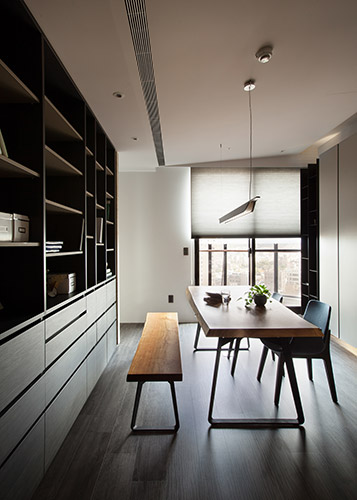 屋主家中藏書與收藏品眾多，在閱讀空間的呈現上，設計師運用系統櫃做出與客廳的隔間，兼顧區域劃分與收納需求。