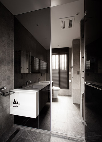 浴室空間以接近天然石材的磁磚，表現本身獨特的紋理變化，同時置入大量收納空間。